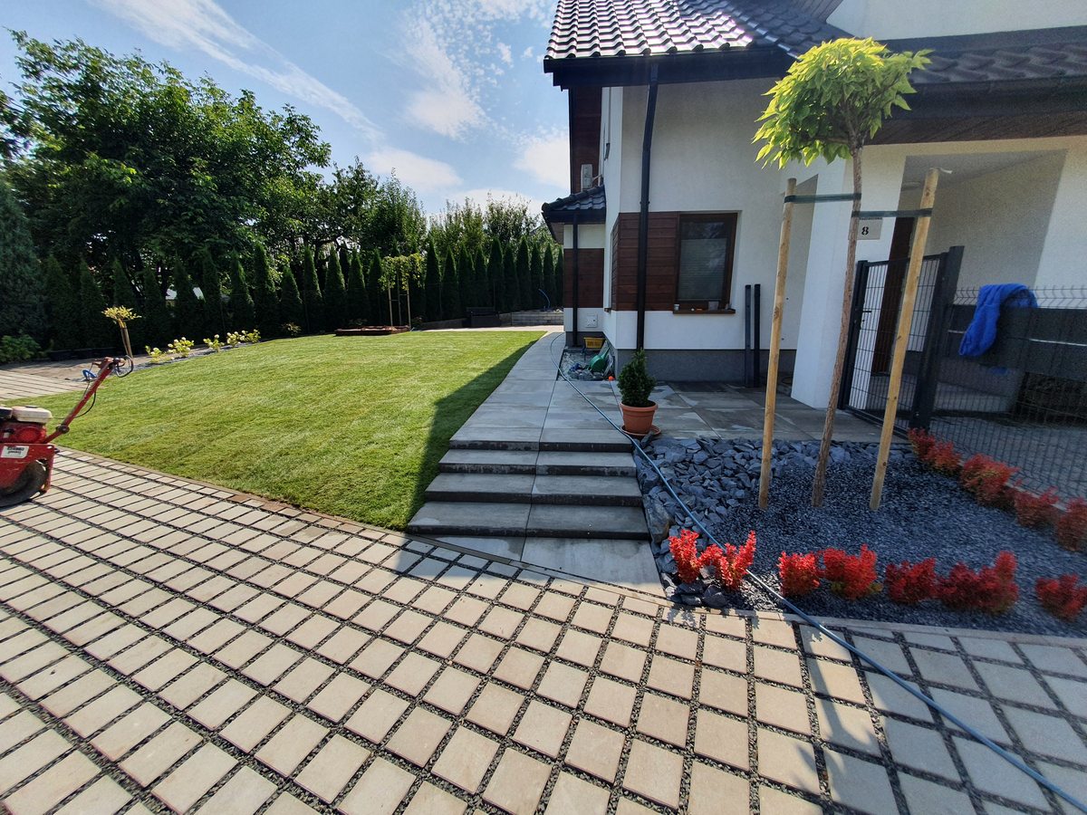 Ogród z trawnikiem, schodami i rabatą kwiatową